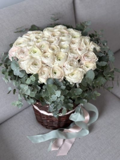 Gęsta kompozycja kremowych jaskrów z zielonym eukaliptusem w plecionym koszuPoczta Kwiatowa Warszawa